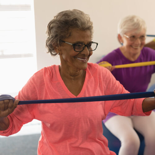 Senior woman exercising with resistance band in fitness studio