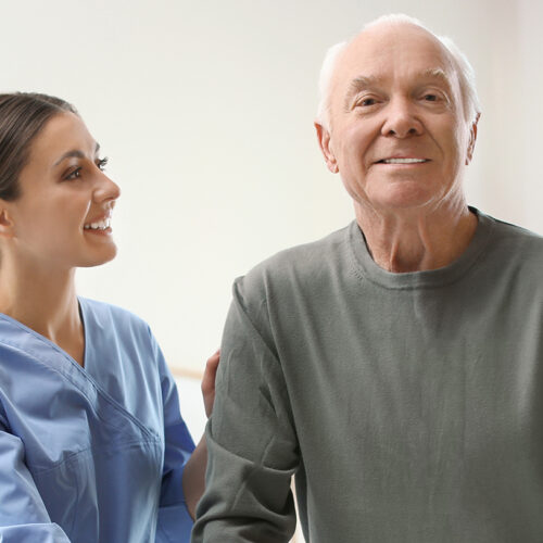 Care worker helping elderly man in geriatric hospice. Banner des