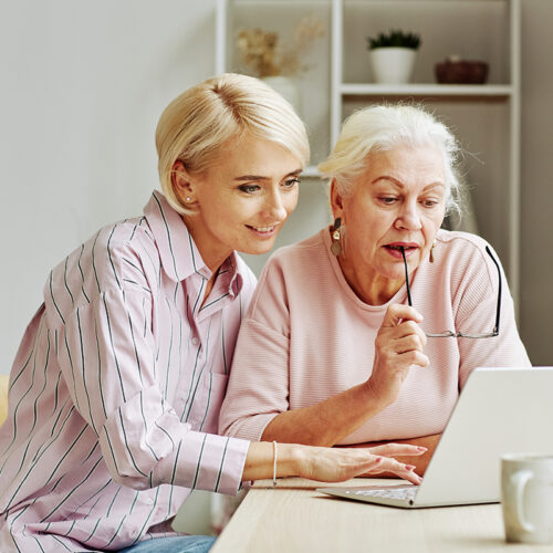 Daughter Helping Senior Woman with Laptop